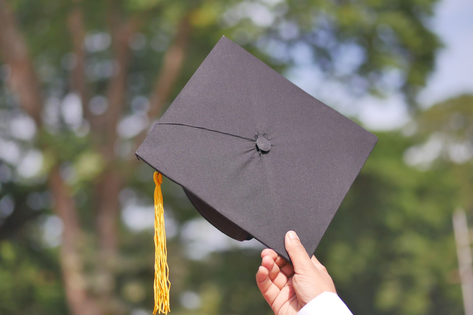 hand holding academic cap with string